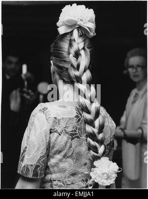 Femme à la mode avec tresse longue liée à grandes fleurs et ruban de décoration de la Couronne et fin de Braid, 1965 Banque D'Images