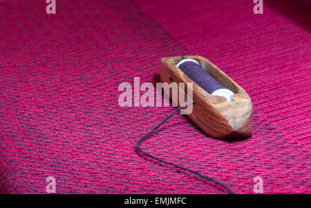 Libre d'une navette en bois avec bobine filetée assis sur tissus with copy space Banque D'Images