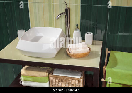 Détail d'une salle de bains moderne avec lavabo et accessoires, meuble de salle de bains vert et 600x600 Banque D'Images