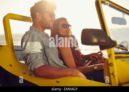 Portrait de beau jeune couple assis ensemble dans une voiture. Jeune couple romantique appréciant la compagnie des uns et des autres en voiture. Banque D'Images