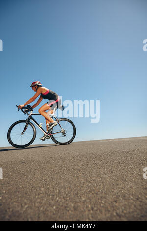 Image des femmes cyclist riding bicycle en bas de la colline. Pour l'entraînement des athlètes d'un événement cycliste compétition de triathlon. Banque D'Images