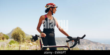 Image de femme déterminée à la cycliste de l'hôtel. Fit woman wearing sportswear et casque de vélo à à copyspace. Banque D'Images