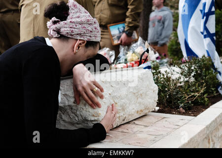 Jérusalem, Israël. 22 avr, 2015. Une femme reste à la pierre tombale de son être cher, d'un deuil dans sa tombe au cimetière militaire du Mont Herzl sur le jour du Souvenir. Ce Yom Hazikaron, Jour commémoratif de l'Israël est tombé des militaires et des victimes d'attentats terroristes, commémore 23 320 disparus. Credit : Alon Nir/Alamy Live News Banque D'Images