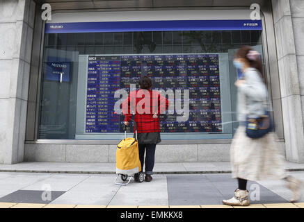 Tokyo, Japon. 22 avr, 2015. Une femme regarde une carte électronique montrant l'indice boursier à Tokyo, Japon, le 22 avril 2015. L'indice Nikkei 225 question-sauté 224,81 points, ou 1,13  %, à partir de mardi à 20 133,90, le plus élevé depuis avril 2000. fermer © Stringer/Xinhua/Alamy Live News Banque D'Images