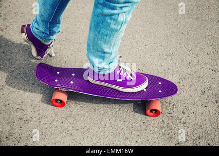 La planche en jeans, des pieds avec fragment de skate, avec photo, correction tonale retro ancien style instagram Banque D'Images