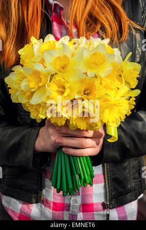 Silhouette de fille aux cheveux rouge avec bouquet de jonquilles mains.Selective focus Banque D'Images