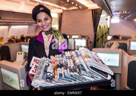 Virginia,Dulles,aéroport international,IAD,terminal,Etihad Airways,classe,à bord,cabine,femme asiatique femme femme,agent de vol,uniforme,offrant newsp Banque D'Images