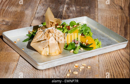 Fromage de chèvre au four de la Méditerranée en papier parchemin. Banque D'Images