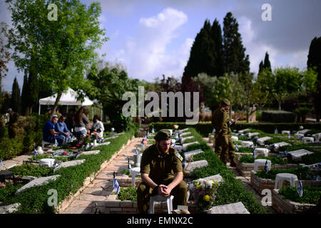 Jérusalem. 22 avr, 2015. Un soldat israélien est situé en face de la tombe de son camarade mort au cours d'une commémoration du Jour du Souvenir au cimetière militaire dans Kiryat-Shaul, le 22 avril 2015. Israël Mercredi marque le Jour du Souvenir pour commémorer les soldats tombés. © JINI/Tomer Neuberg/Xinhua/Alamy Live News Banque D'Images