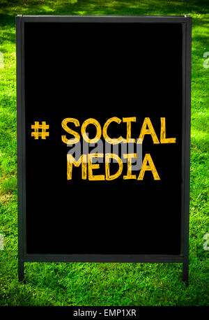 Social Media Hashtag message sur trottoir tableau noir signer contre fond d'herbe verte. Copie de l'espace disponible. Image Concept Banque D'Images