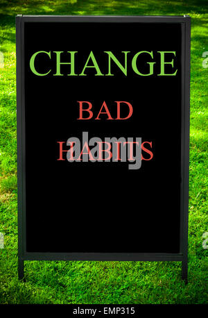 Changer de mauvaises habitudes message sur trottoir tableau noir signer contre fond d'herbe verte. Copie de l'espace disponible. Image Concept Banque D'Images