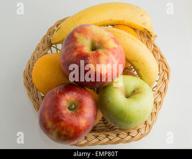 Panier rempli de bananes fraîches, vert et rouge des pommes et des oranges. Banque D'Images