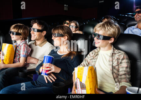 Les familles souriant le visionnage en 3D movie Banque D'Images