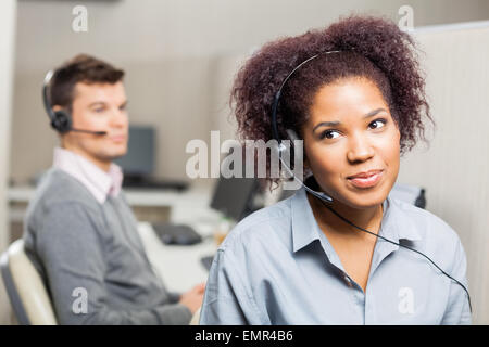 Female customer service representative wearing headset in office Banque D'Images