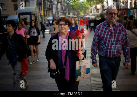 Barcelone, Catalogne, Espagne. Apr 23, 2015. Une femme marche le long de la Rambla de Barcelone portant roses le 23 avril 2015. Saint George's est présent dans les rues de Barcelone. La tradition de Sant George's day hommes commandes pour donner une rose et d'adresses pour les femmes dans un signe d'amour. © Jordi Boixareu/ZUMA/Alamy Fil Live News Banque D'Images