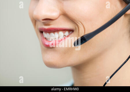 Smiling female customer service agent wearing headset Banque D'Images