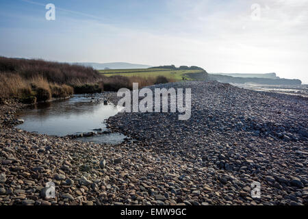 La rivière coule au large de l'Holford collines de Quantock et sur la plage de galets à Kilve à Somerset, England, UK Banque D'Images