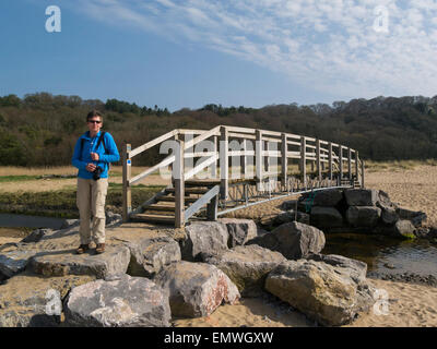 Femme walker crossing bridge plus Nicholaston comprimé sur tous les pays de Galles Sentier du littoral de la péninsule de Gower Swansea South Wales UK Banque D'Images