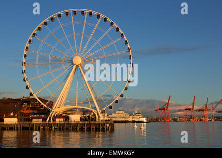 WA10402-00...WASHINGTON - Elliott Bay et le front de mer de Seattle au coucher du soleil, avec la grande roue et de contre-son bac. Banque D'Images