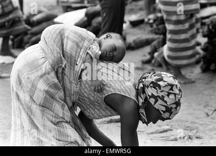 Photos prises lors du Daily Mirror's tentent d'atteindre les camps de réfugiés d'Onitsha et Asaba pendant le conflit du Biafra. Une femme avec son enfant sur son dos. 16 juillet 1968. Banque D'Images