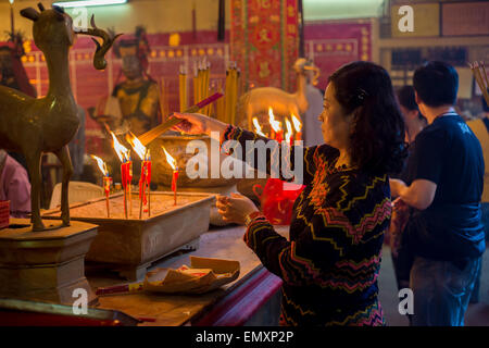 Femme chinoise l'encense herbal éclairage bâtons dans un monastère à Hong-Kong (Temple Man Mo) Banque D'Images