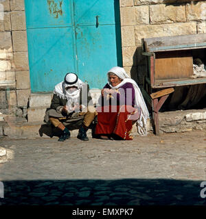 Ein altes Ehepaar sitzt vor der Eingangstür votre rond à Beer Sheba, Israël Ende des années 1970 er Jahre. Un ancien couple sitting in fro Banque D'Images