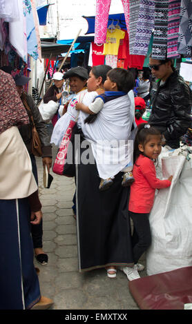 Consommateurs à la recherche de produits sur l'affichage pour la vente au marché d'Otavalo, Équateur Banque D'Images