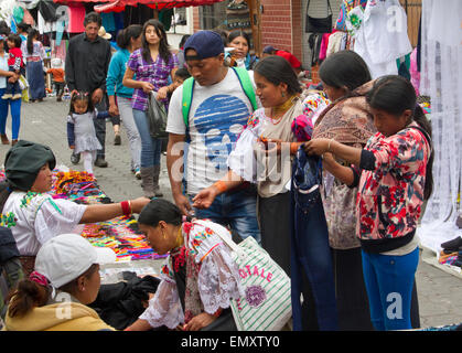 Consommateurs à la recherche de produits sur l'affichage pour la vente au marché d'Otavalo, Équateur Banque D'Images