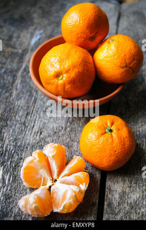 La mandarine mûre et de fruits panier plein de mandarines sur fond de bois Banque D'Images