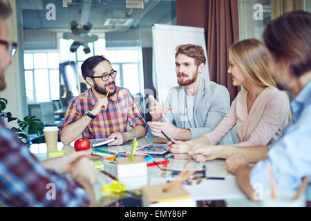 L'équipe d'affaires à la jeune homme à parler de nouvelles tendances Banque D'Images