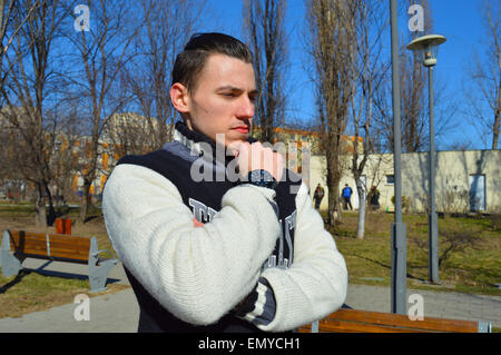 Jeune homme montre-bracelet avec profil sur sa main en park Banque D'Images