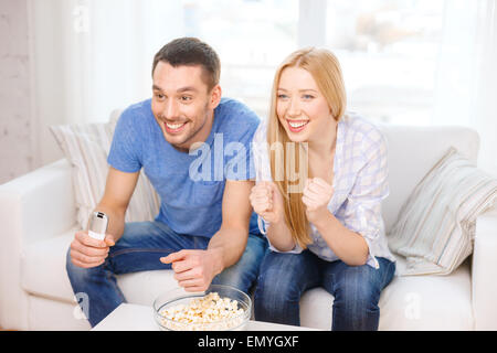 Smiling couple avec popcorn sports team cheering Banque D'Images