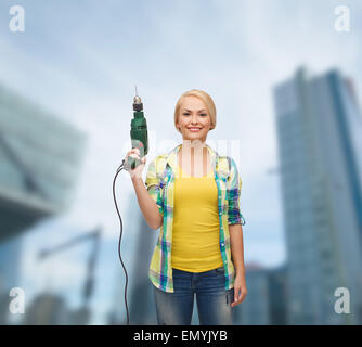 Femme souriante avec perceuse Banque D'Images