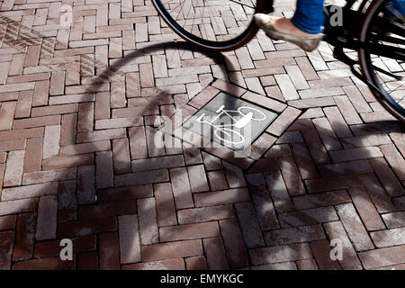 Un vélo panneau sur la route avec l'ombre d'un cycliste passe par, Rijksmuseum, Amsterdam, Pays-Bas Banque D'Images