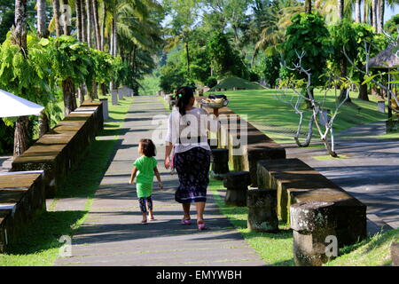 Une dame Balinais, accompagné de sa fille, dont l'obligation est la prestation de sacré quotidien offrant de les temples dans le complexe. Banque D'Images