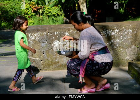 Une dame balinais sur son devoir dans l'exécution de tous les jours, offrant aux temples sacrés dans un resort à Ubud, Bali. Banque D'Images