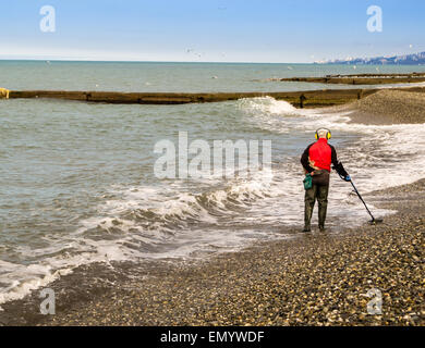 ADLER, Russie 30 mars 2015 - un pensionné utilise son temps libre à l'aide d'une chasse au trésor détecteur de métal sur le front de mer Banque D'Images