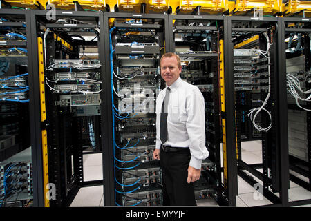 Une bonne gestionnaire datacenter posant devant le datacenter en rack. Banque D'Images