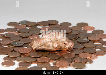 La pépite de cuivre de flottement de la Péninsule Supérieure du Michigan allongé sur un lit de penny. La matière première et le produit fini. Banque D'Images