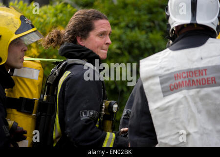 Femme London Fire Brigade (LFB) pompier assister à un feu de pavillon à Herne Hill, Londres du sud. s Banque D'Images