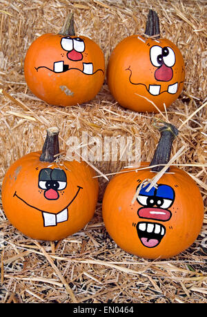 Funny faces peintes sur les citrouilles d'automne des balles de foin. Banque D'Images