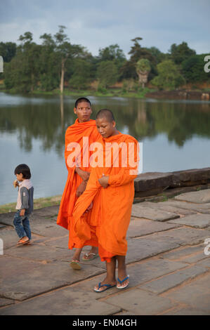 SIEM REAP, Cambodge - 30 octobre 2014 : Novice moines bouddhistes en robe orange marcher pieds nus vers le temple d'Angkor Wat. Banque D'Images