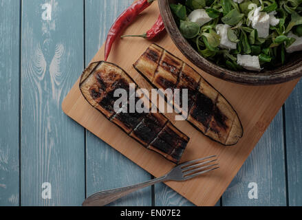 Salade d'aubergines grillées et les moitiés sur une table en bois Banque D'Images