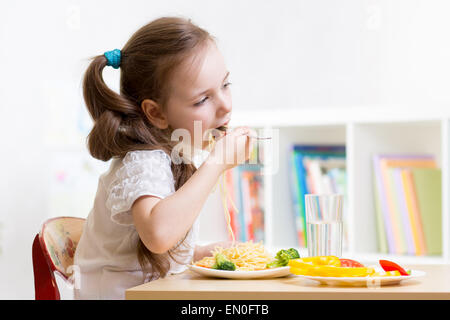 Bambin kid girl consommer des aliments sains à la maison ou au jardin Banque D'Images