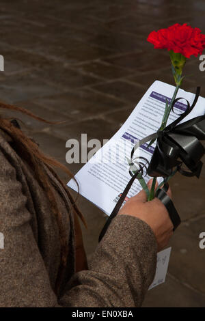 Preston, Lancashire, UK 25 avril 2015. Jeune femme à la rose & Brochure à l'événement le Jour commémoratif de l'Internationale des travailleurs avec le service commémoratif, Mars & rally de reconnaître ceux qui ont été tués, blessés ou devenus malades par le travail chaque année. La commémoration et à la Campagne Drapeau Preston marché cette année est de se rappeler les morts et lutte pour la vie avec la maladie générée par des substances dangereuses comme l'amiante. Banque D'Images