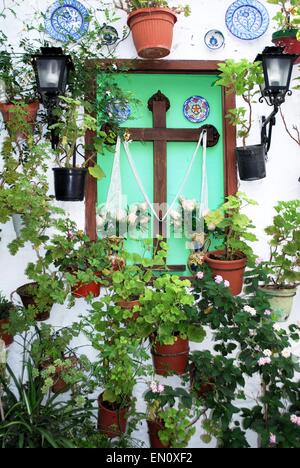 Croix en bois entourée de plantes mur dans le quartier Barrio la Villa de Priego de Córdoba, Cordoue, Province, Andalusia, Spain. Banque D'Images