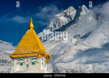 Parc national de Sagarmatha (Népal) - 12 mars 2015 : l'Ama Dablam peak au coucher du soleil, avec le haut d'un stupa à l'avant-plan Banque D'Images