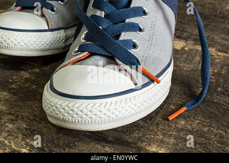 Sneakers sur une ancienne surface en bois. Des chaussures de sport Banque D'Images