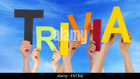 De nombreux peuples caucasiens et mains tenant tout droit caractères ou lettres Building Le mot anglais Futilités On Blue Sky Banque D'Images