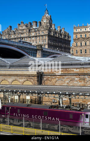 The Flying Scotsman debout à la gare de Waverley d'Édimbourg est à l'hôtel Balmoral à l'arrière-plan. Banque D'Images